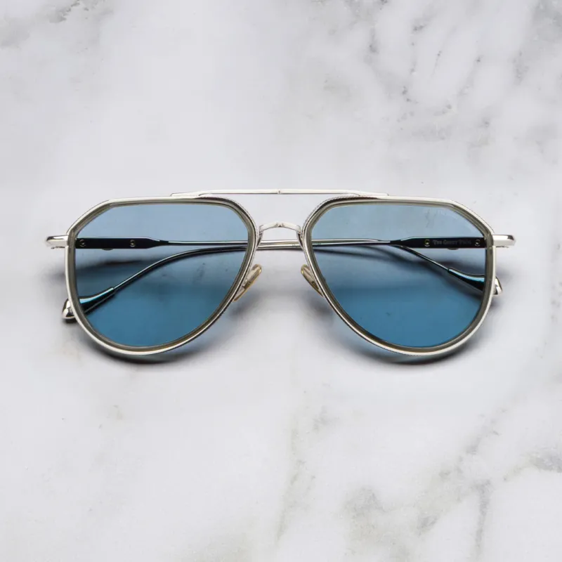 An image of the Cutler and Gross The Great Frog Limited-Edition Triumph Aviator Sunglasses in Silver/Olive frame frontal view with arms closed marble background.