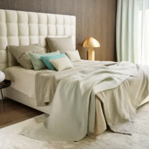 Leitner Corbeille firm decorative pillow styled on a made bed with neutral linen bedding.