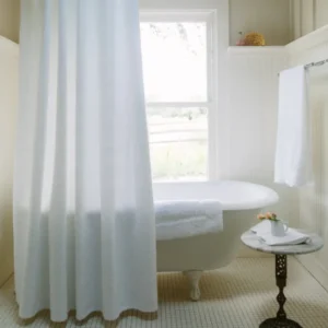 Peacock Alley Vienna Matelassé ivory shower curtain in classic white bathroom with clawfoot tub.