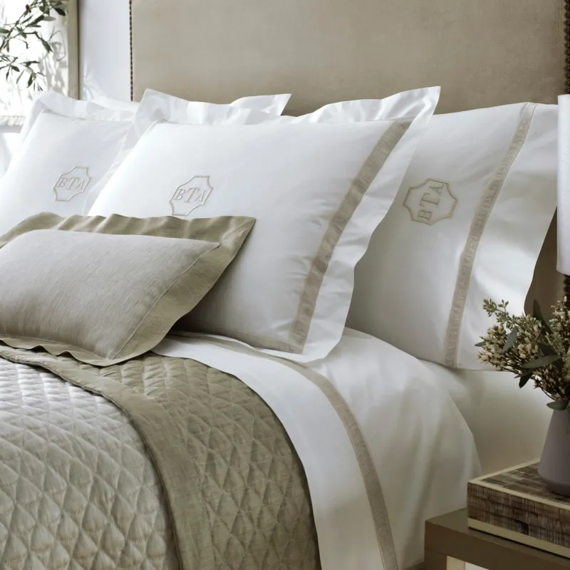 Home Treasures Alina ivory and taupe quilted coverlet with monogrammed euro shams on styled bed.