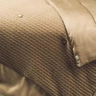 Kumi Kookoon camel cable-knit cashmere throw with silk lining and button detail.