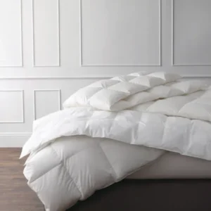 Matouk Valletto ivory goose down comforter with pillow on bed, baffle-box construction.