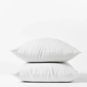 Coyuchi Relaxed Linen pillowcase pair in white, two pillows stacked on white background.